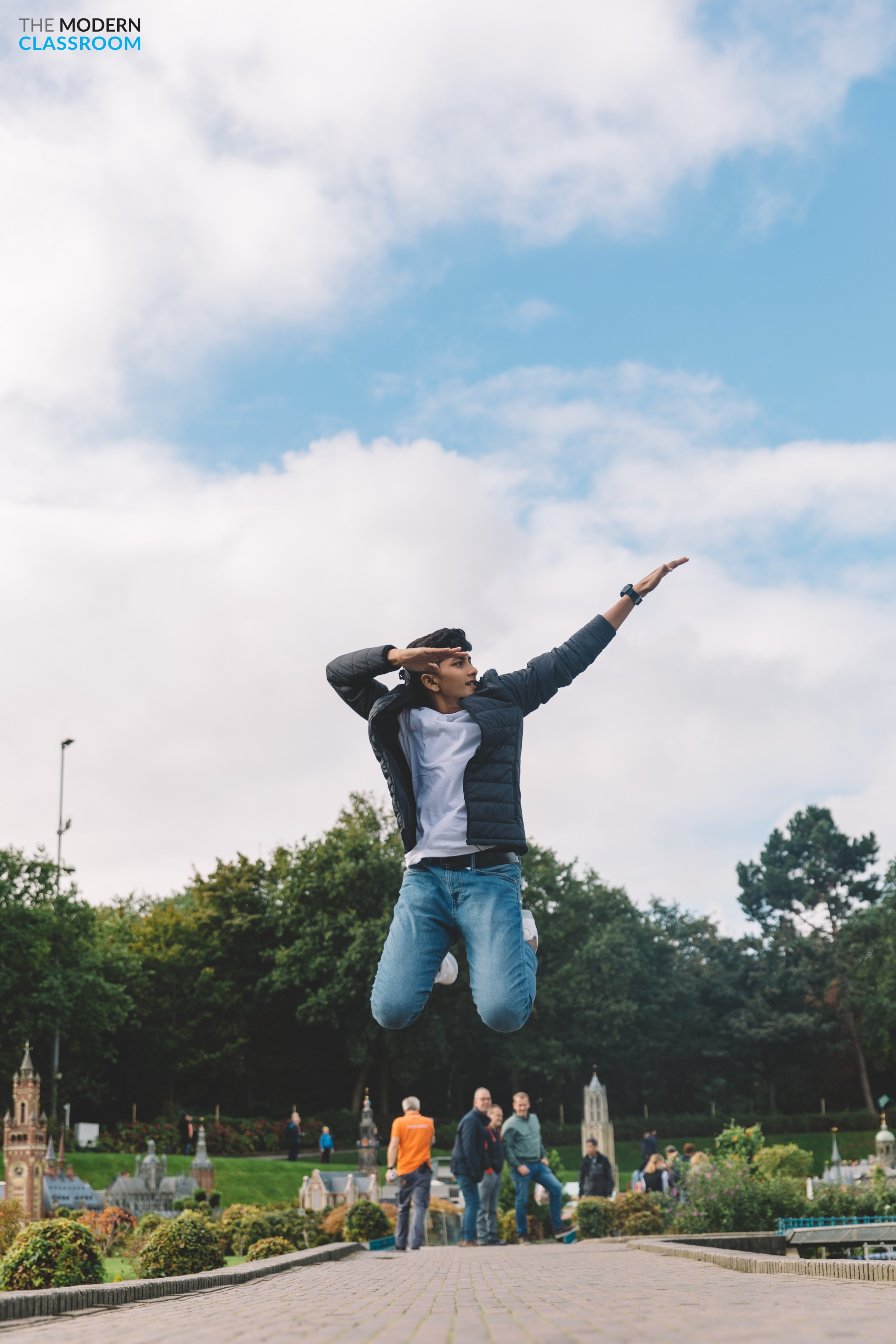 Student jumping with joy in a park during an educational travel program